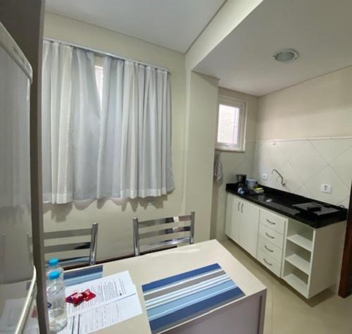 a room with a kitchen with a sink and a counter at POSIT APARTAMENTOS in Curitiba