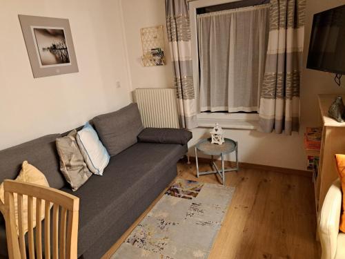 sala de estar con sofá y mesa en Ferienwohnung im Grünen en Wolfurt