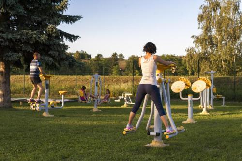 a woman is playing on a playground in a park at Grand Hotel Primus - Terme Ptuj - Sava Hotels & Resorts in Ptuj