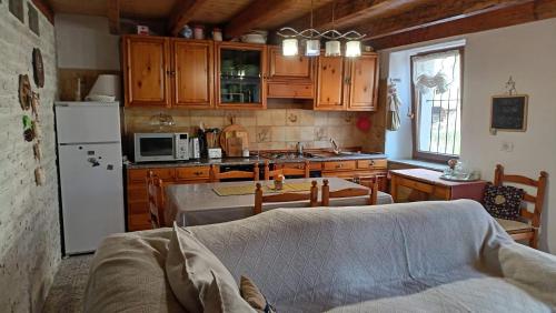 una cocina con armarios de madera y un sofá en una habitación en Molini .LAGHI en Malga Campiluzzi Inferiore