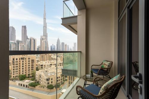 a balcony with two chairs and a view of the city at Waves Holiday Home - Chic Apartment With Dubai Skyline Views in Dubai
