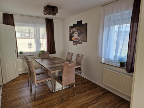 - une salle à manger avec une table et des chaises en bois dans l'établissement Ferienwohnungen Waldina, à Siegen