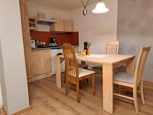 kuchnia z drewnianym stołem i krzesłami w kuchni w obiekcie Ferienwohnung im Grünen w mieście Wolfurt
