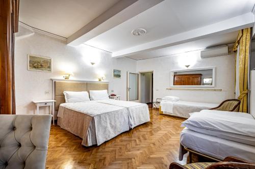 ein Hotelzimmer mit 2 Betten und 2 Stühlen in der Unterkunft Hotel Alessandra in Florenz