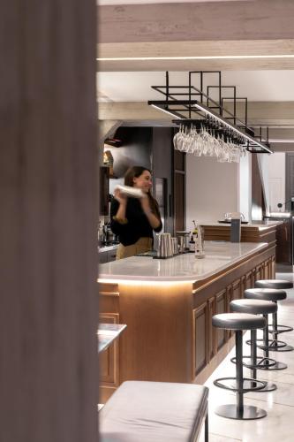 a woman standing behind a bar in a kitchen at InnAthens in Athens