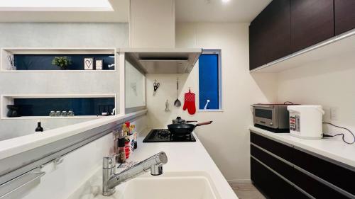 a small kitchen with a sink and a stove at Love House in Osaka
