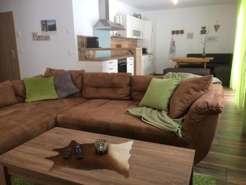 - un salon avec un canapé brun et une table dans l'établissement Appartementhaus Angelika, à Nittenau