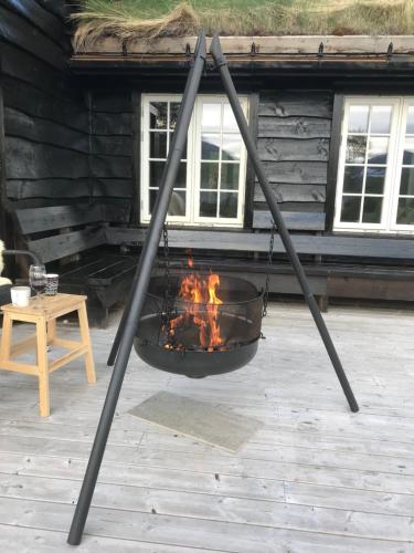 a fire pit in front of a log cabin at Remestøylflotti Hyttegrend in Hovden