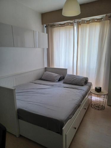 un lit dans une chambre avec une grande fenêtre dans l'établissement Studio à Nice avec piscine, à Nice