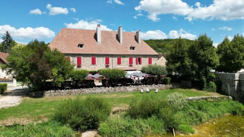 a large house with red shutters and a yard at Hôtel Restaurant Chez Gervais in Quingey