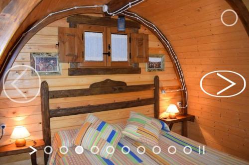 a bedroom with a bed in a wooden cabin at El Mirador de la Mancha in Villarrubia de los Ojos