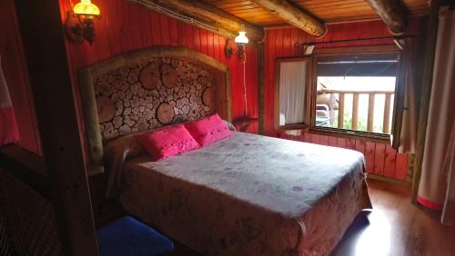 a bedroom with a bed with pink sheets and a window at El Mirador de la Mancha in Villarrubia de los Ojos