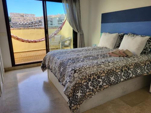 een slaapkamer met een bed en uitzicht op de stad bij Precioso apartamento, todo equipado, con piscinas in Manilva