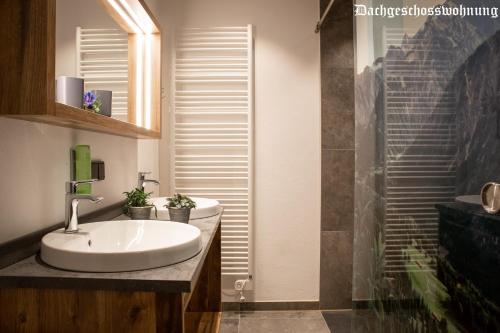 a bathroom with a white sink and a shower at Brunnenhof Oberstdorf - Ferienwohnungen mit Hotel Service in Oberstdorf