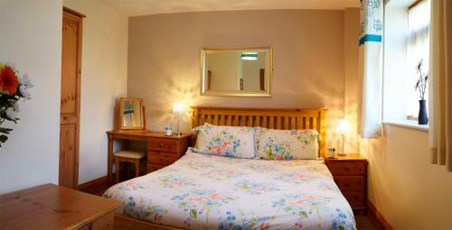 a bedroom with a bed and a table and a mirror at Filey Holiday Cottages in Filey