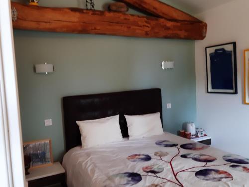 sypialnia z łóżkiem z narzutą i kwiatami w obiekcie LA FERME DE CAPUCINE w mieście Culhat