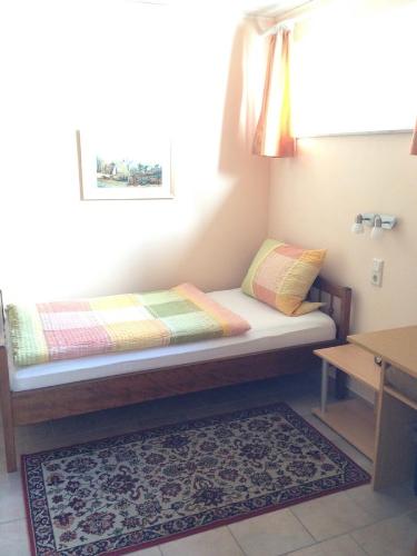 a small bed in a room with a rug at Guesthouse AirMinis in Düsseldorf
