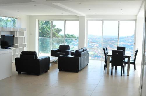 a living room with couches and a table and chairs at The Seventeen Apartment Hotel in Kampala