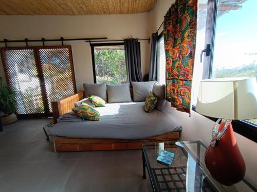 um quarto com uma cama num quarto com janelas em The African House em Tolox