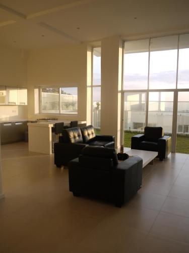 a living room with couches and a kitchen with windows at The Seventeen Apartment Hotel in Kampala