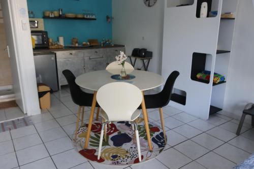 a kitchen with a table and chairs in a room at Le Colibri et le Frangipanier in La Trinité