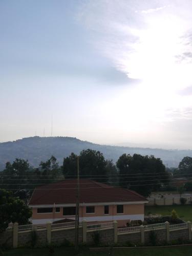a house with a brown roof and a fence at The Seventeen Apartment Hotel in Kampala