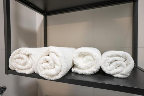 a bunch of towels on a shelf in a bathroom at Bright stylish apartment in a top location in Vienna