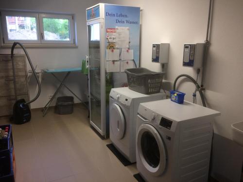 a laundry room with a washing machine and a shower at Appartementhaus Angelika in Nittenau