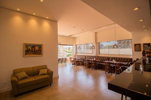 a restaurant with a couch and a table and chairs at Prado Hotel in Amparo
