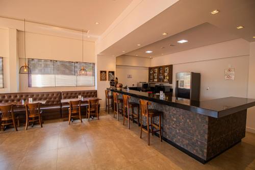 un restaurante con bar con taburetes de madera en Prado Hotel, en Amparo