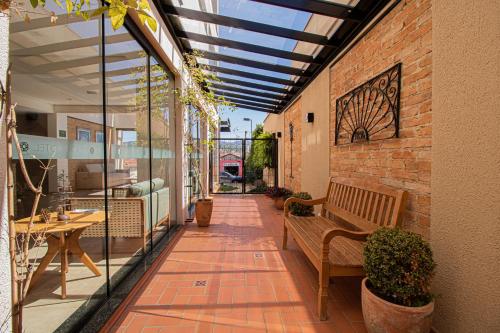 a patio with a bench and a brick wall at Prado Hotel in Amparo