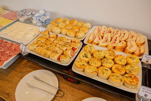 a buffet of different types of food on trays at Prado Hotel in Amparo