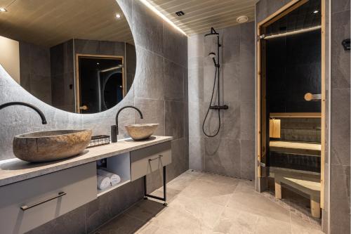 La salle de bains est pourvue de 2 lavabos et d'une douche. dans l'établissement Santa's Hotel Rakka, à Kilpisjärvi
