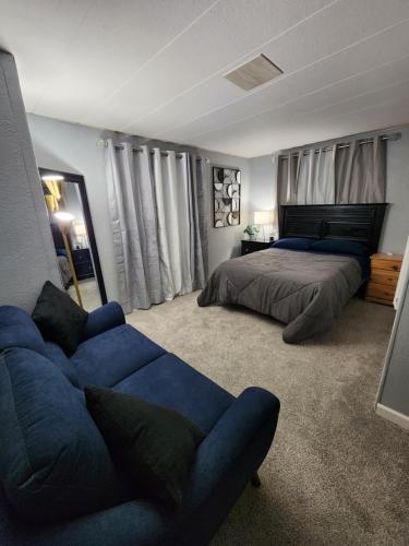 a bedroom with a blue couch and a bed at 1 Bdrm Grand Canyon Bridge Rental in Dolan Springs