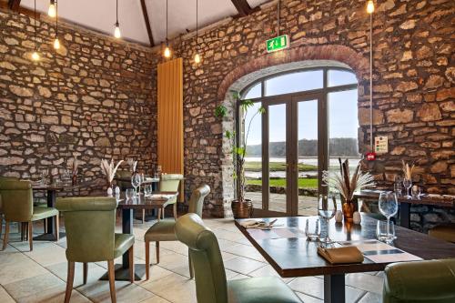 a restaurant with tables and chairs and a brick wall at Slebech Park Estate in Wiston