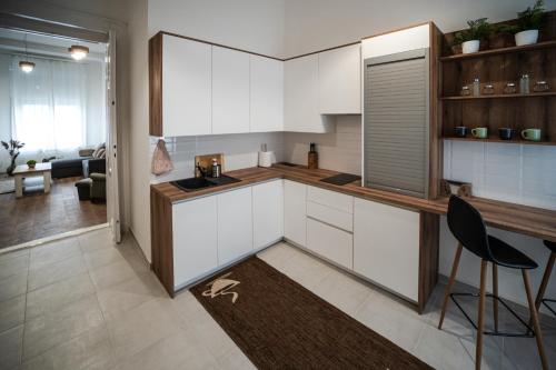 a kitchen with white cabinets and a table and chairs at Volenter Lux Apartment Uno in Baja