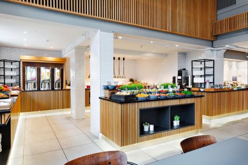 a restaurant with a buffet of food on a counter at Quality Hotel Augustin in Trondheim