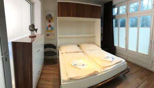 1 dormitorio con 1 cama con 2 toallas en Exclusive FEWO in Warnemünde, 150m to the beach, 2 bathrooms, 2 bedrooms, sauna, WiFi and much more. en Rostock