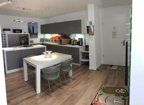 a kitchen with a white table and a white counter top at Exclusive FEWO in Warnemünde, 150m to the beach, 2 bathrooms, 2 bedrooms, sauna, WiFi and much more. in Rostock