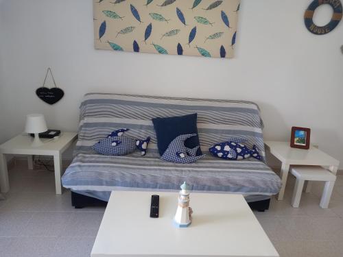 Habitación con cama con almohadas azules. en Las Islas Apartment en Corralejo