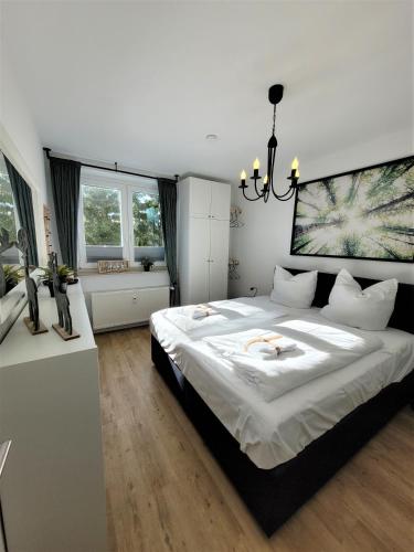 Un dormitorio con una cama grande y una lámpara de araña. en Winterberg Appartement 21122, en Winterberg