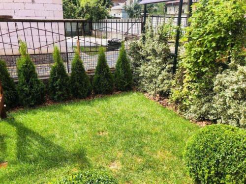 a garden with green grass and bushes and a fence at Julia in Umanʼ