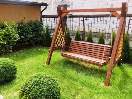 drewniana ławka siedząca na trawie w ogrodzie w obiekcie Julia w mieście Humań