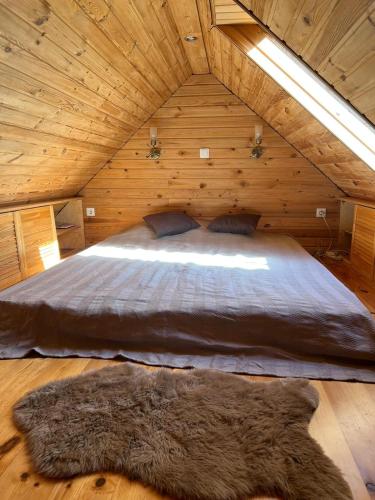 1 dormitorio con 1 cama en una cabaña de madera en Katase Suvemaja en Katase