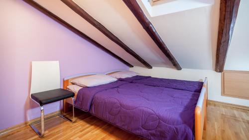 a bedroom with a purple bed and a chair at Apartment Medak Split City Center in Split
