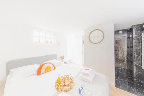 a white bedroom with a white bed and a mirror at CMG Cherche Midi - Sèvres in Paris