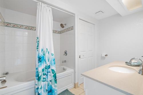 La salle de bains est pourvue d'un rideau de douche et d'un lavabo. dans l'établissement Stunning Waterfront Pool Home Walk to Beach & Restaurants Large Private Pool, à Clearwater Beach