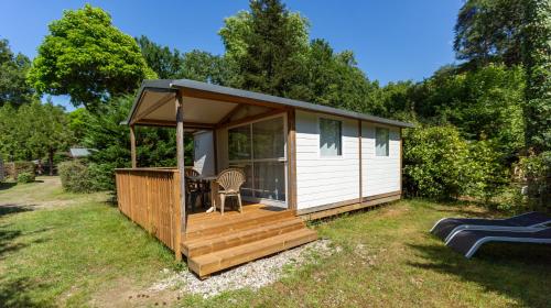 a small cabin with a deck and a patio at Camping L'Etang D'Ardy *** in Saint-Paul-lès-Dax