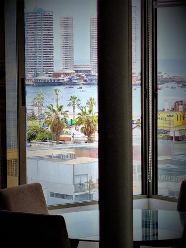 uma vista para o oceano a partir da janela de um quarto de hotel em Cavancha Exclusivo em Iquique