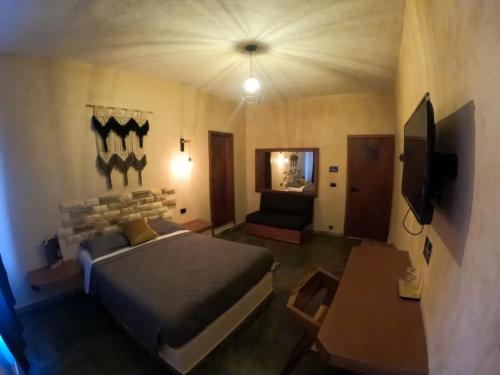 a bedroom with a bed and a tv and a couch at relax hotelito in Cárdenas